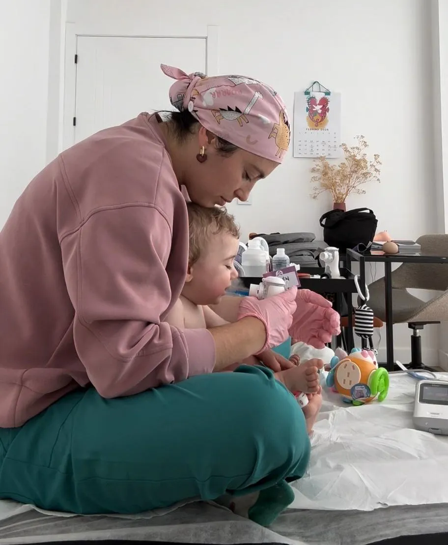 Fisioterapeuta pediátrica atendiendo a una madre con su bebé